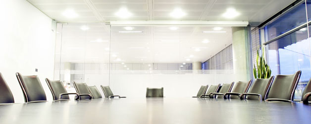 Photo of empty conference room with large meeting table and chairs