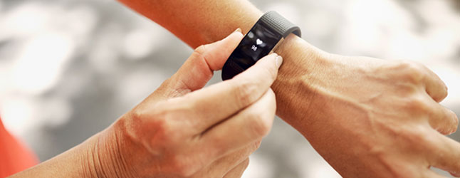 Closeup of a person adjusting a digital health wearable device on their wrist