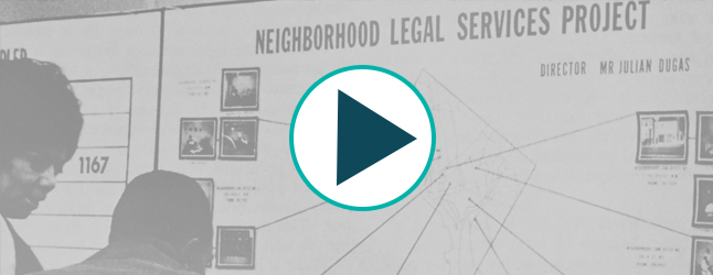 Neighborhood Legal Services Project poster board with diagrams and photos with two individuals facing the poster board