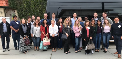 Group of professionals standing outside in front of a bus