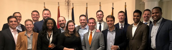 Group photo of professionals in front of flags